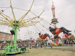 students riding a carnival ride at UMBC Homecoming