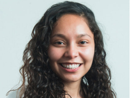 headshot of smiling woman with long, wavy hair.