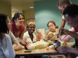 A diverse group of students smiling and socializing at a table