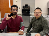 Dong Li (right) and graduate student Riishav Guptaa demonstrate how smart phone blood pressure monitoring may work.