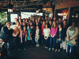 A group of students and alumni standing in a restaurant.
